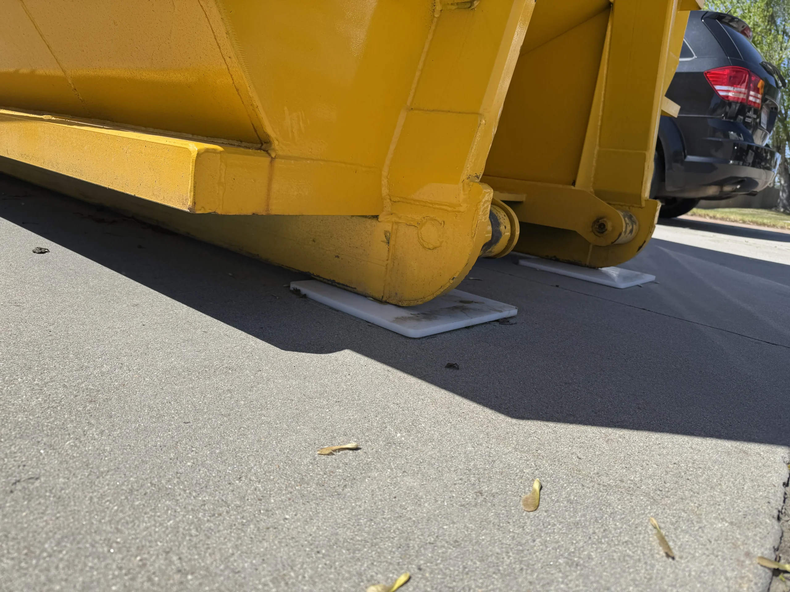 Close-up of RolliSkates protecting a driveway under a Done Right dumpster